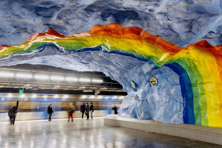 Art in the subway, Stockholm. Pictured is Stadion station, painted in baby blue, with a rainbow running over the ceiling.